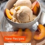 A bowl of peach ice cream with fresh peach slices on a white plate.