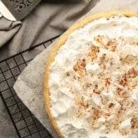 Cooked coconut cream pie on a wire cooling rack
