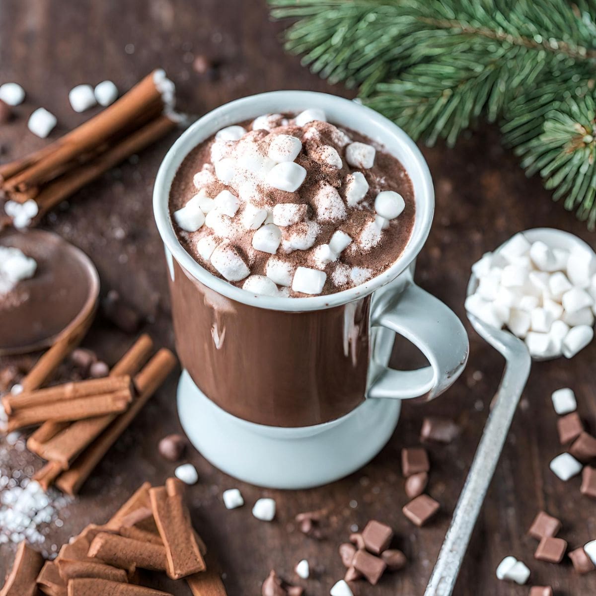 A cup of hot chocolate with marshmallows on top, on a wooden table.